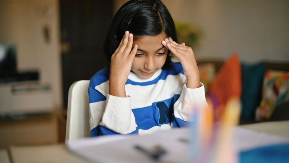 Girl sitting with her hands on head while studying