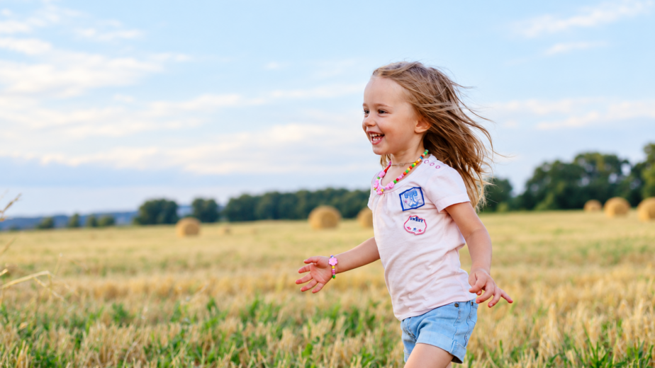 Bambina felice tra i campi di grano